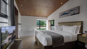 A modern bedroom with a large bed, a flat-screen TV, a window, and a painting on the wall. - Heart Retret Seasons Village (Foshan)