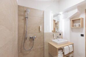 A modern bathroom with a shower, a sink, and a mirror. - odilum (Mondsee)