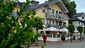 Un hôtel doté d’un balcon, d’un espace extérieur aménagé et d’une enseigne indiquant « Villa Wauj ».
