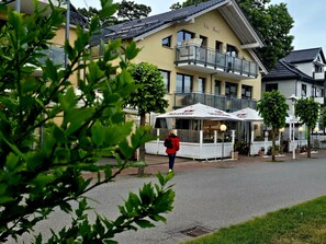 Ein Hotel mit Balkon, Sitzgelegenheiten im Freien und einem Schild mit der Aufschrift 'Villa Wauj'.