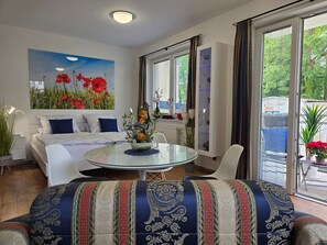 Ein modernes Wohnzimmer mit einer Couch, einem Glastisch und einem Gemälde von roten Blumen.