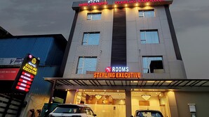 Un hotel con un cartello che indica 'STERLING EXECUTIVE' e '24% CAMERE'.