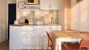 A compact kitchen with a microwave, toaster, coffee maker, and a clock on the wall. - Charming appartment La Pironnière - Les Sables - 4 people (Les Sables-d´Olonne)