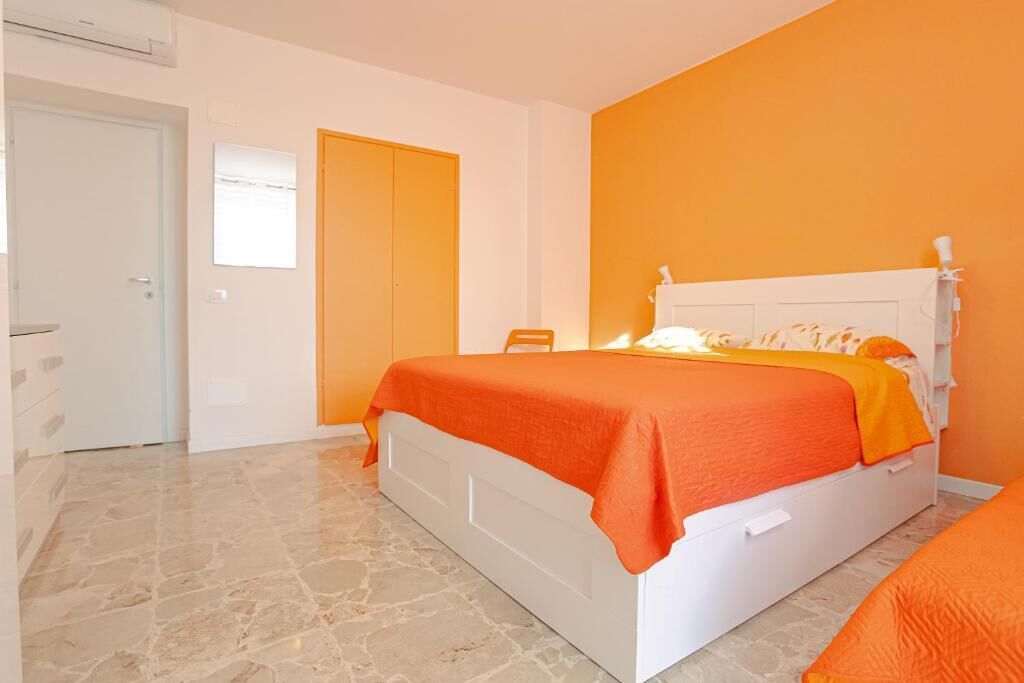 A bedroom with a bed, a door, and a window.