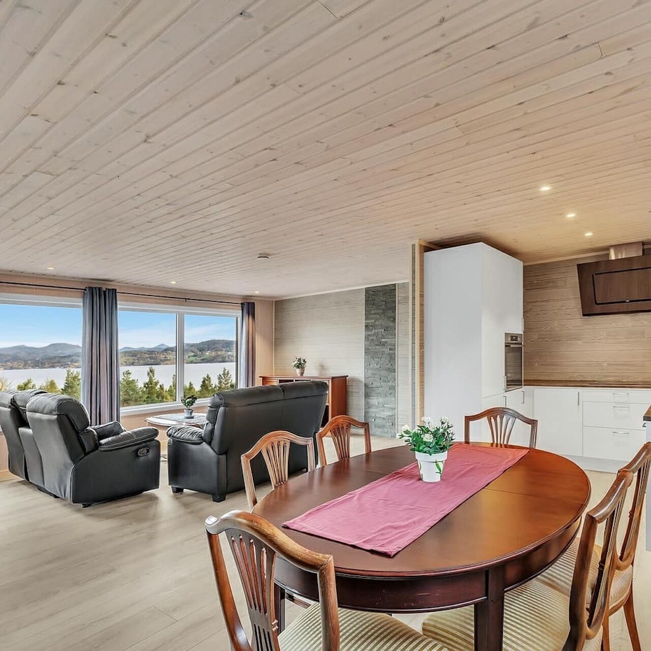 A modern living room with a dining table, sofas, and chairs.