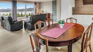 A modern living room with a dining table, sofas, and chairs.