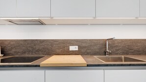 A kitchen with a double sink, a wooden cutting board, and a backsplash. - Apartment 'Talferblick Burg' with Mountain View, Private Terrace and Wi-Fi (Sarentino)