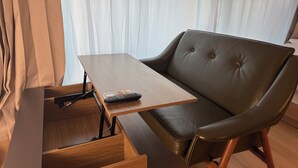 A room with a foldable wooden table, a leather sofa, and a sliding door. - JS Building-503 (Seoul)