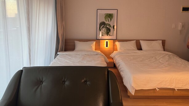A hotel room with two beds, a bedside table with a lamp, a framed picture on the wall, and a telephone. - JS Building-503 (Seoul)
