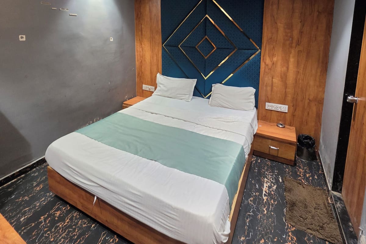 A modern bedroom with a bed, wooden headboard, nightstands, and a ceiling fan.
