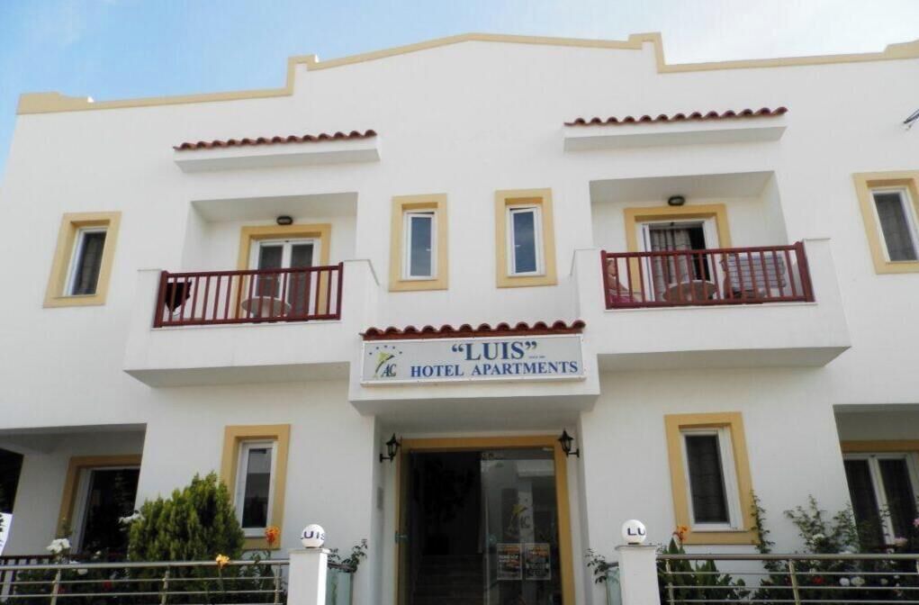 A building with a sign reading 'LUIS HOTEL APARTMENTS.'