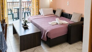 A bedroom with a bed, a desk, and a chair. There is a balcony with a view. - Luis Pool (Kos)