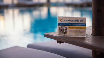 A poolside sign for Luis Pool Snack Bar with a QR code and WiFi access information.