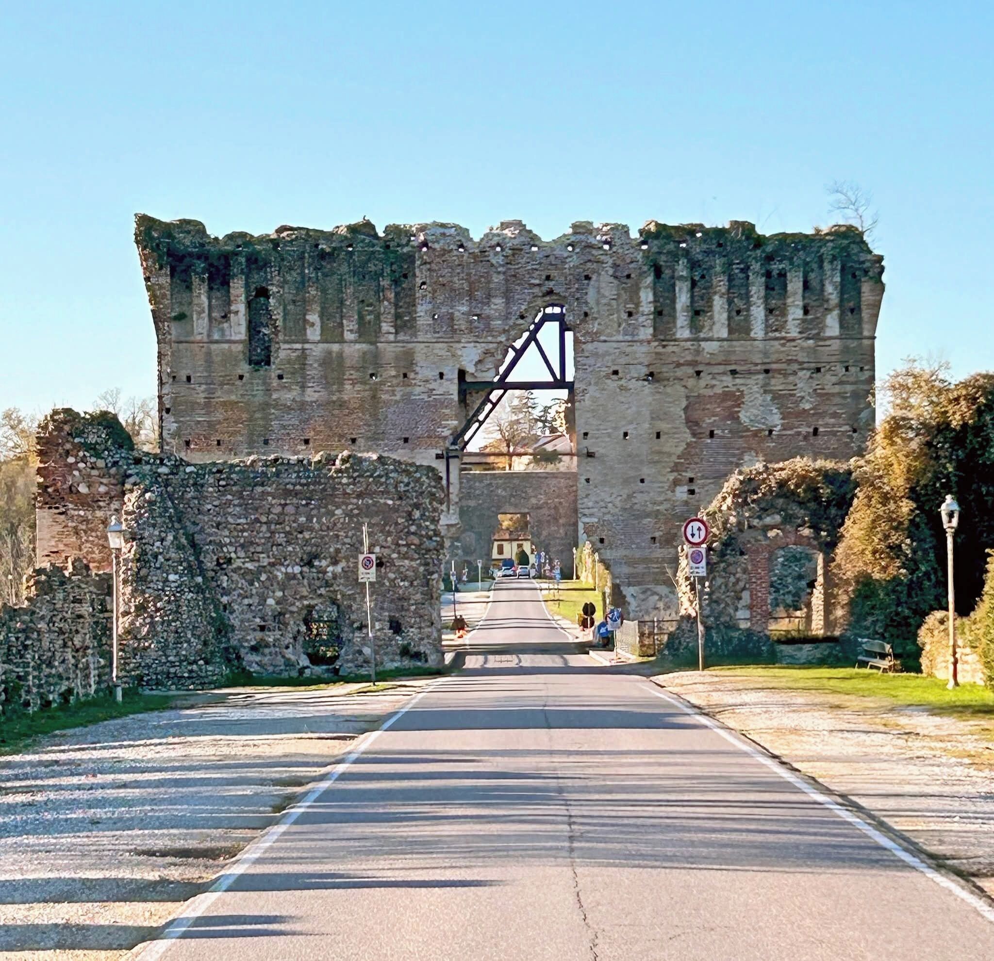 Eine Steinkonstruktion mit Metallgitter, einer gepflasterten Straße und steinernen Mauern an beiden Seiten.