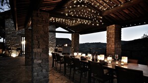 An outdoor dining area with stone pillars, wooden beams, and string lights. - Villa dell’Orso – Secluded Luxury with Private Infinity Pool & Piedmont Views (Piemonte)