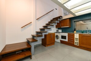 A compact kitchen with wooden cabinetry, a built-in oven, a microwave, and a washing machine. - (ESA121ID) Spacious Duplex in the center of Madrid (Madrid)