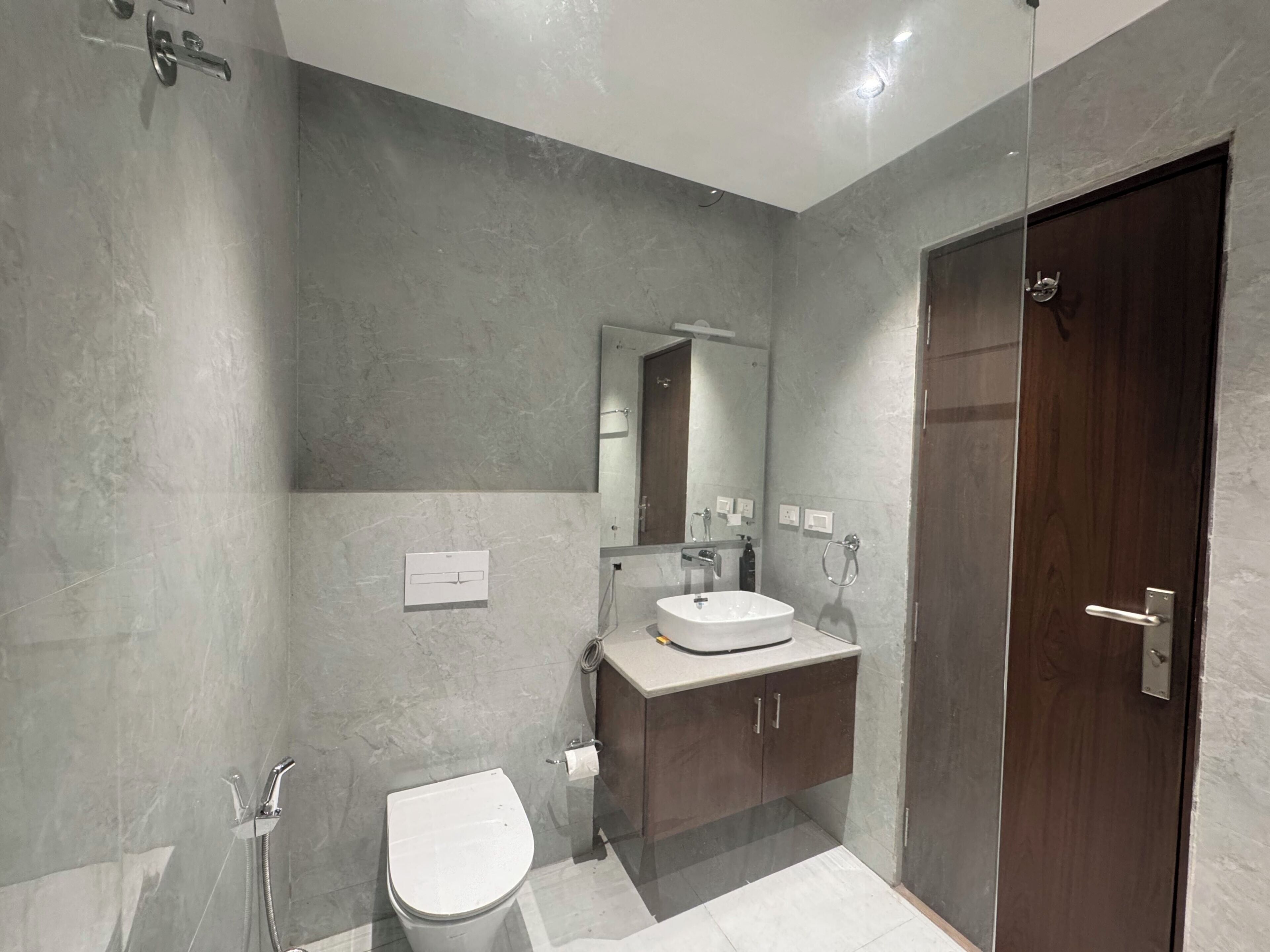 A modern bathroom with a shower, toilet, and sink.