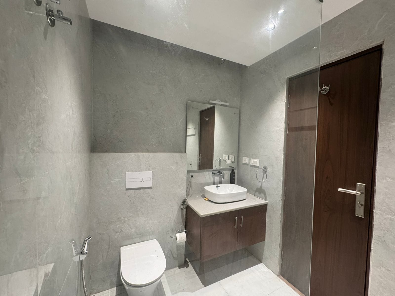 Ett modernt badrum med dusch, toalett och handfat.
