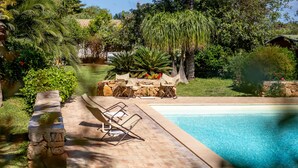 A swimming pool with a stone deck and lounge chairs. - Agriturismo Duca di Castelmonte (Trapani)