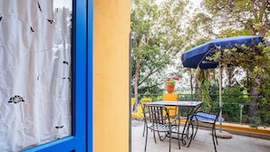 A patio area with a table and chairs, a blue umbrella, and a potted plant. - Agriturismo Duca di Castelmonte (Trapani)
