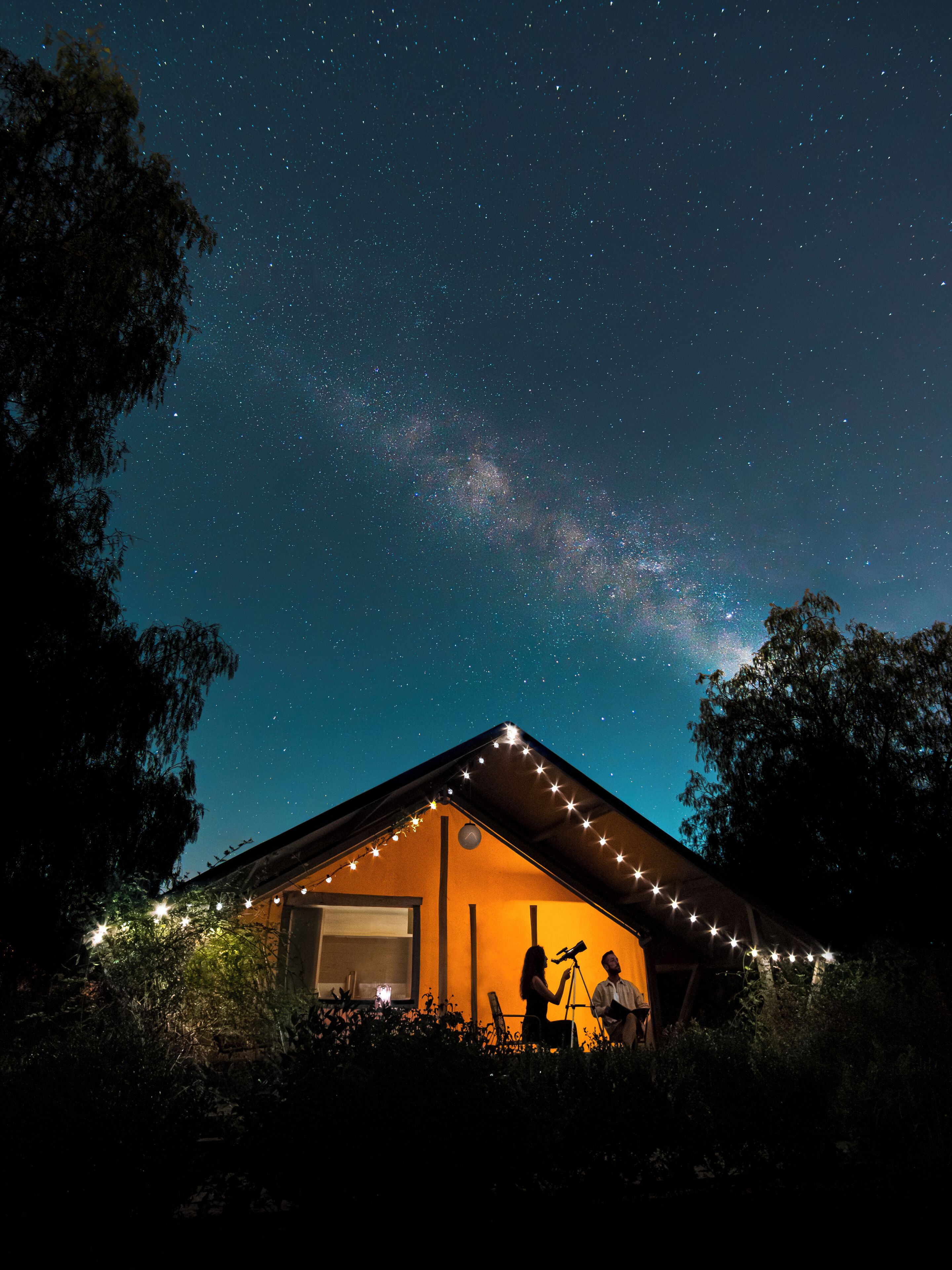 Una casa con un telescopio all'esterno, sotto un cielo stellato.