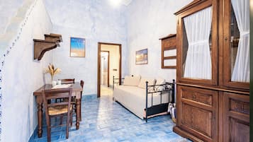 Une chambre à coucher comprenant un lit, une armoire en bois, un bureau avec des chaises et une table à manger.