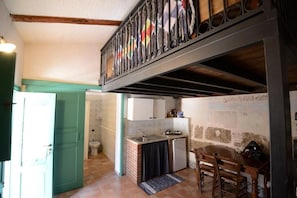 A kitchen with a dining area, a staircase, and a view of the outside. - Agriturismo Duca di Castelmonte (Trapani)