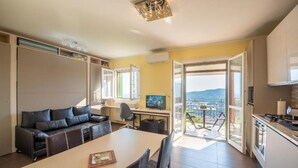 Un soggiorno moderno con divano, tavolo da pranzo e televisione.