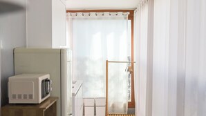 A compact kitchen with a microwave, a small refrigerator, and a wooden cabinet. - JS building- 505 (Seoul)