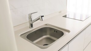 A modern kitchen with a stainless steel sink, a single faucet, and a white countertop. - JS building- 505 (Seoul)