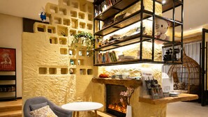 A cozy living room with a fireplace, a bookshelf, and two chairs. - Han Exotic inn (Zhangjiajie)
