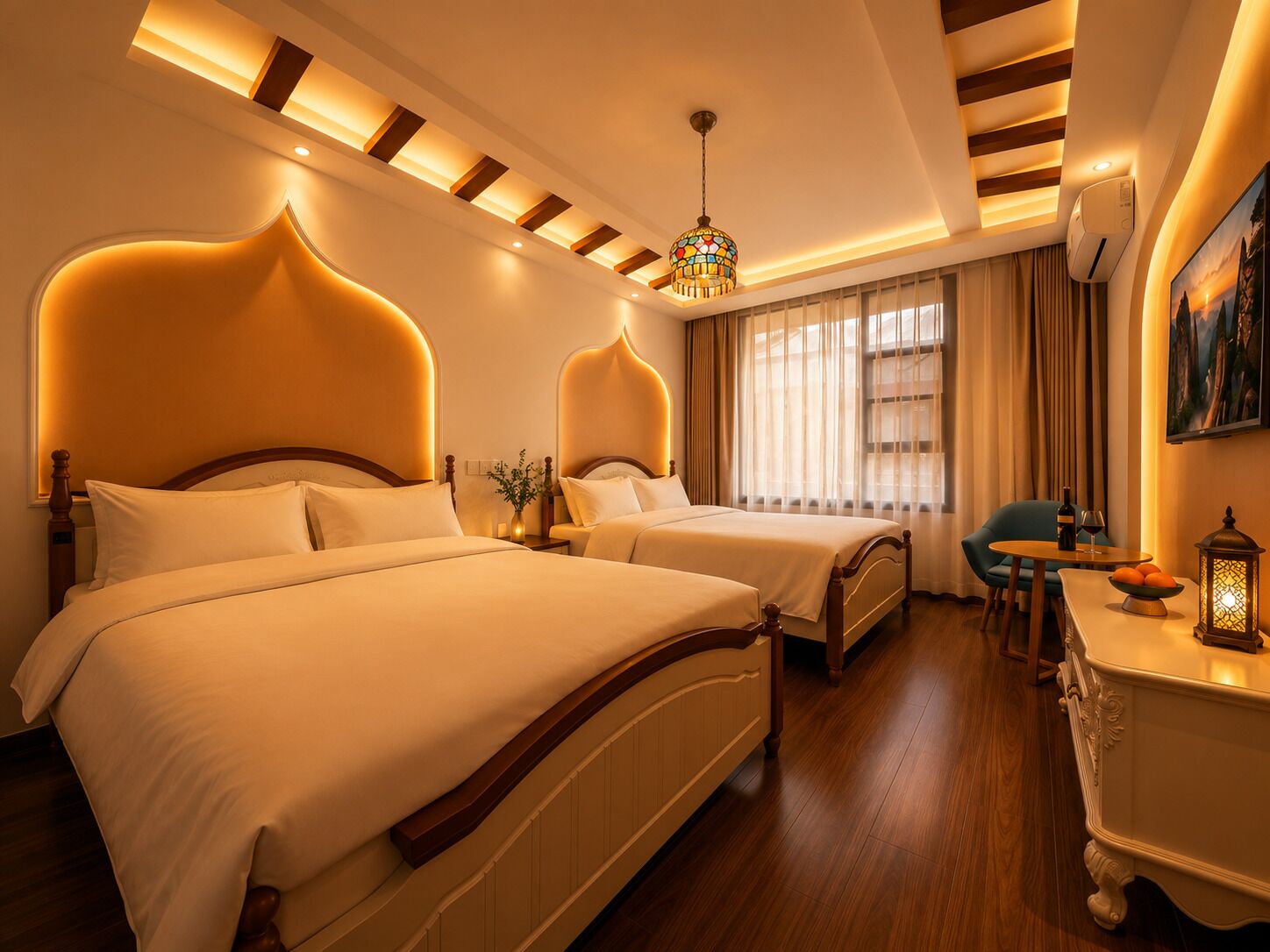 A hotel room with two beds, a chandelier, a desk with a chair, and a painting on the wall.