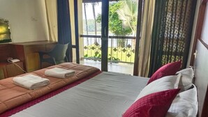 Ein Hotelzimmer mit Bett, Schreibtisch, Stuhl und Blick ins Freie.