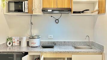 A compact kitchen with a microwave, stove, and built-in oven.