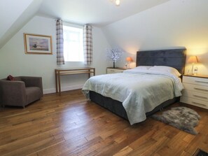 Ein Schlafzimmer mit Bett, Schreibtisch, Stuhl, Lampe und einer Zimmerpflanze.
