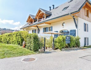 Ein modernes Haus mit Balkon, Garage und einem gepflegten Garten.
