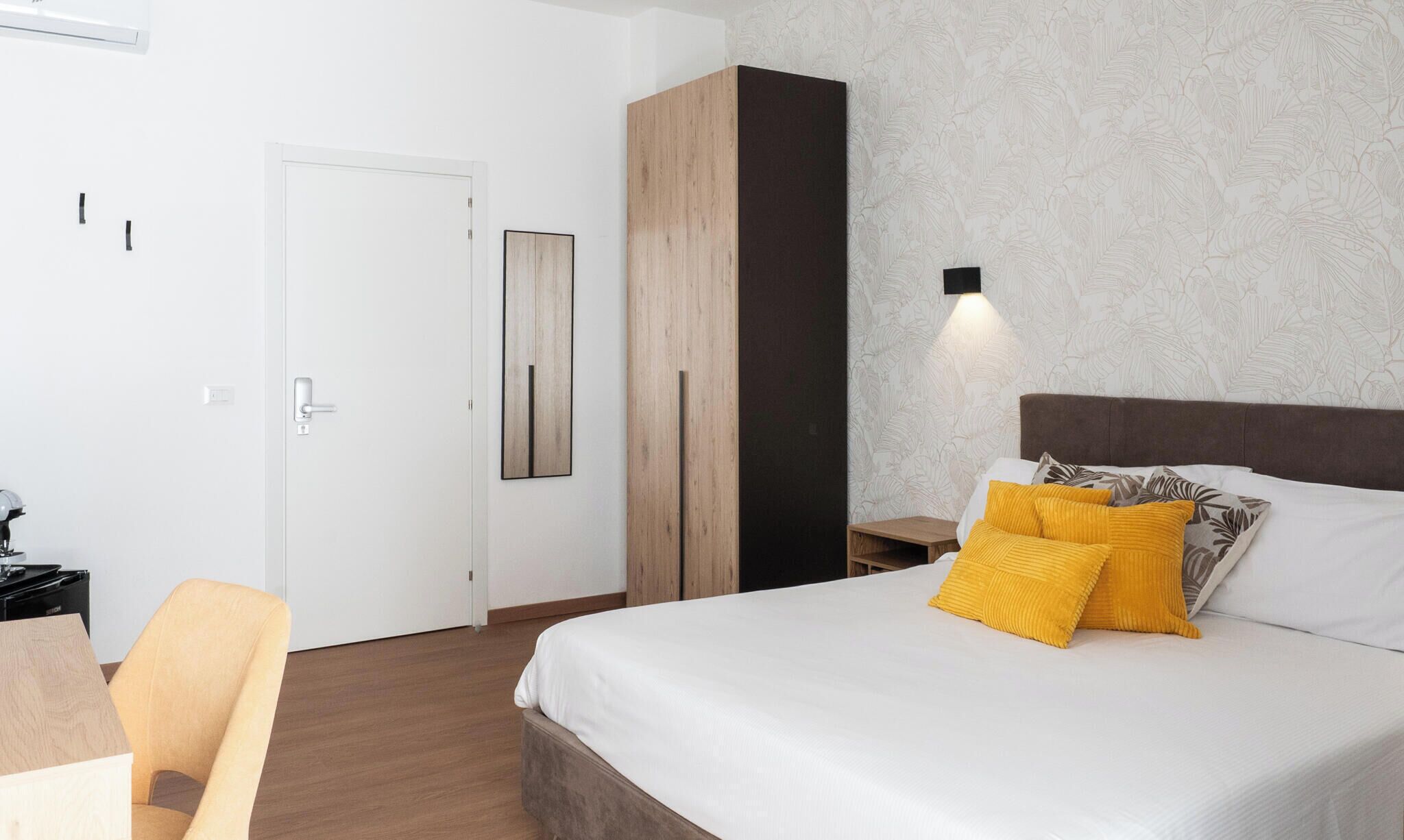 Un dormitorio con cama, armario, escritorio y silla.