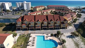 A hotel with a swimming pool, multiple buildings, and a view of the ocean. - Spacious 4bedroom 3bathroom townhouse casual elegance w/ lagoon views! 2 Pools! (Pensacola Beach)