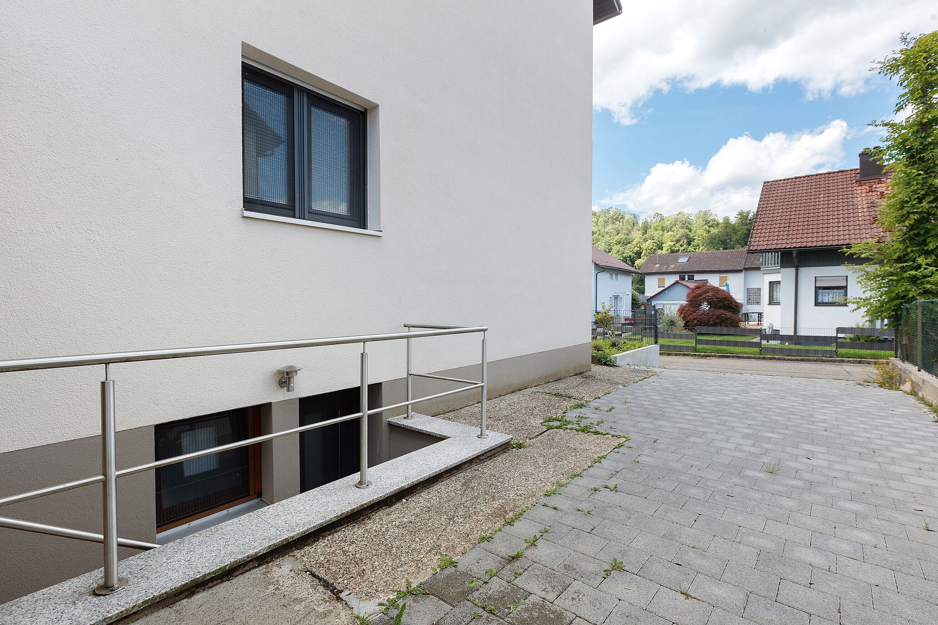 A modern building with a metal staircase and a paved walkway.