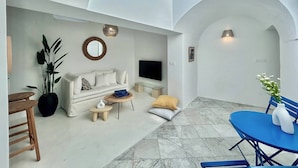 Un soggiorno moderno con un divano, TV e un'area pranzo con tavolo e sedie.
