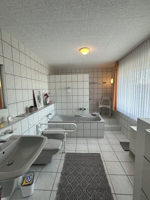 Un bagno moderno dotato di vasca, doccia, lavandino e toilette.