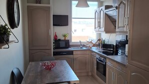 Una cocina moderna con una mesa de comedor, sillas, microondas, horno y armarios.