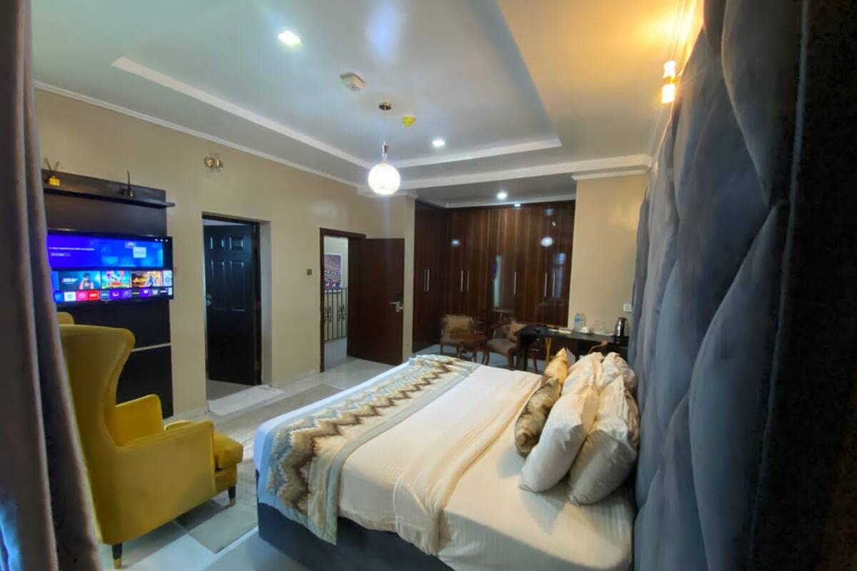 Ein modernes Hotelzimmer mit Bett, Fernseher, Schreibtisch und Stuhl.