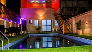 Un edificio con piscina, escaleras y mobiliario exterior.