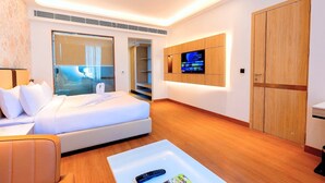 Une chambre d’hôtel moderne équipée d’un lit, d’une télévision, d’un canapé et d’une armoire en bois.