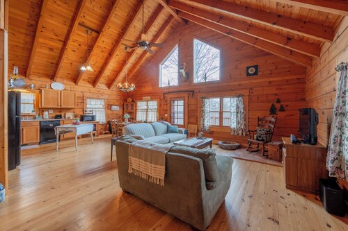 Peaceful log cabin retreat with wraparound deck, open living space, full kitchen, cozy bedrooms & scenic wooded views.