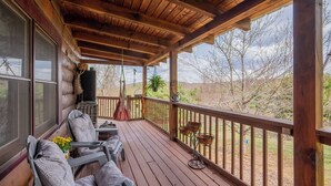 Une terrasse en bois avec des sièges extérieurs, une pergola et une vue sur le paysage environnant.