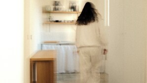 En person går genom en korridor, och i bakgrunden syns ett köksområde.