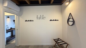 A hallway with a 'hello' sign, a mirror, and a wooden rack. - Enchantment of the Lake app Riva Two-room apartment with Terrace and A/C (Molina)