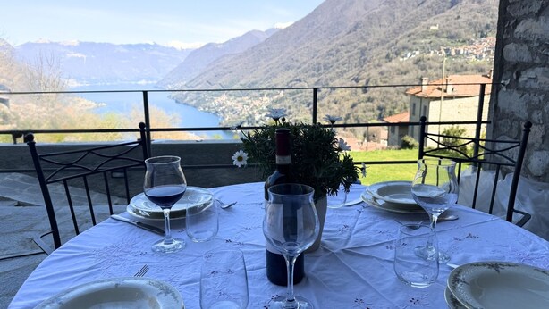 A table set for dining with a view of a lake and mountains. - Enchantment of the Lake app Riva Two-room apartment with Terrace and A/C (Molina)